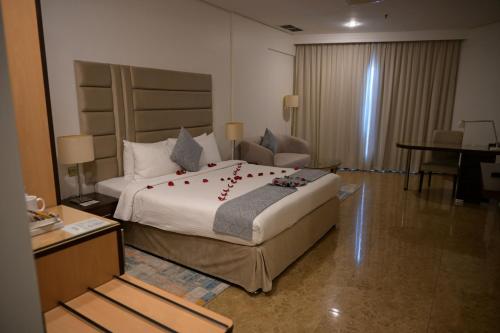 a bedroom with a large bed with red flowers on it at Best Western Plus Mahboula in Kuwait