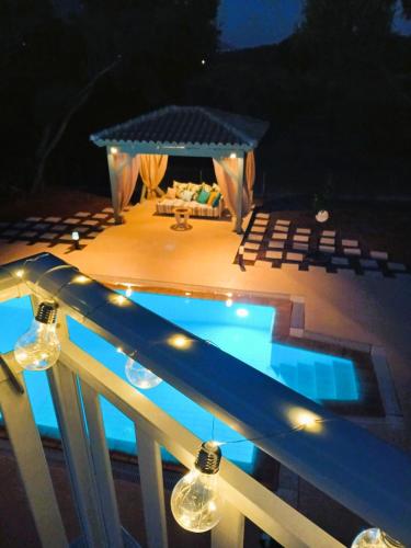 a swimming pool on a deck at night with lights at Sti Physi in Keramiaí