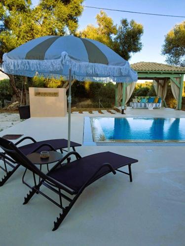 a blue and black umbrella sitting next to a pool at Sti Physi in Keramiaí