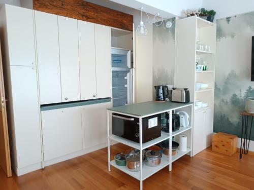 a kitchen with white cabinets and a counter with a microwave at Appartamenti Vacanze Casa -Residence Albare - check in Vacanze Casa - Marilleva 900 in Marilleva