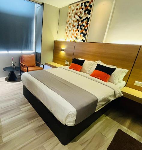 a bedroom with a large bed with orange pillows at Extreme Boutique Hotel in Kluang