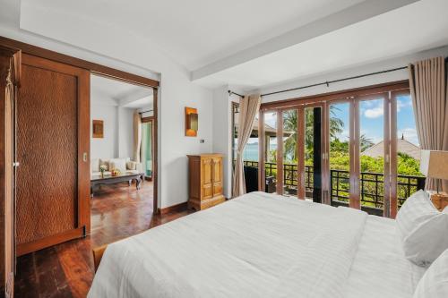 a bedroom with a bed and a balcony at The Kala in Amphoe Koh Samui
