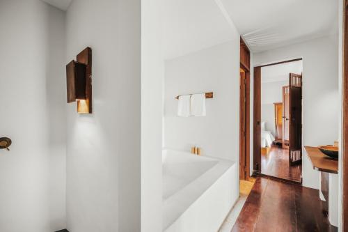 a bathroom with a large white tub in a room at The Kala in Amphoe Koh Samui