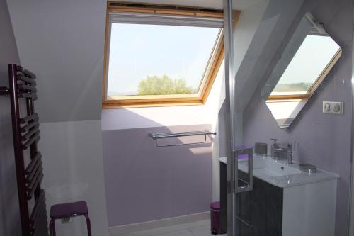 La salle de bains est pourvue d'un lavabo et d'une fenêtre. dans l'établissement Chambre D'hotes Le Clos Fleuri, à Criel-sur-Mer