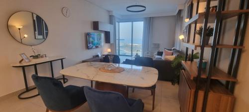 a living room with a table and chairs and a mirror at Skyline Luxe Sea view Apartemnt in Lusail
