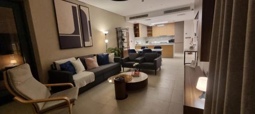 a living room with a couch and chairs and a kitchen at Skyline Luxe Sea view Apartemnt in Lusail