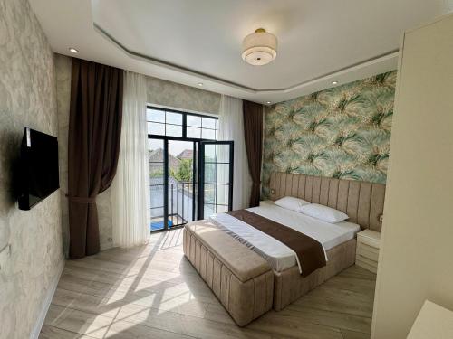 a bedroom with a bed and a large window at MM House in Gabala