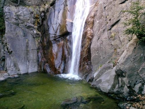 a waterfall on the side of a mountain with a pool of water at Pensión Fonda Vilalta in Ribes de Freser