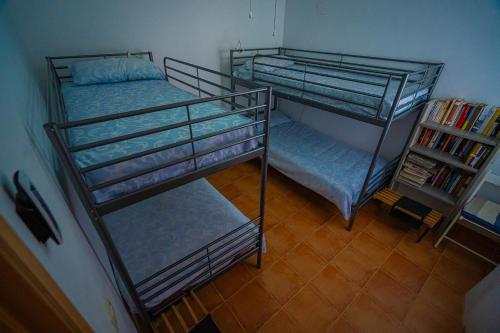 two bunk beds in a room with a book shelf at Piso Playa de Canet in Canet de Berenguer
