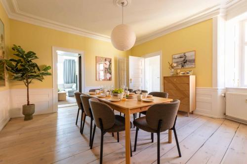 a dining room with a wooden table and chairs at Lovely Apartment Overlooking King's Garden in Copenhagen