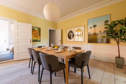 a dining room with a wooden table and chairs at Lovely Apartment Overlooking King's Garden in Copenhagen