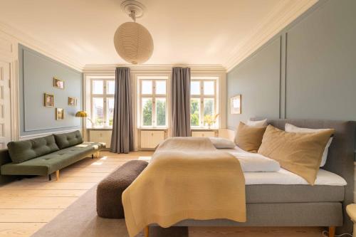 a bedroom with a large bed and a couch at Lovely Apartment Overlooking King's Garden in Copenhagen