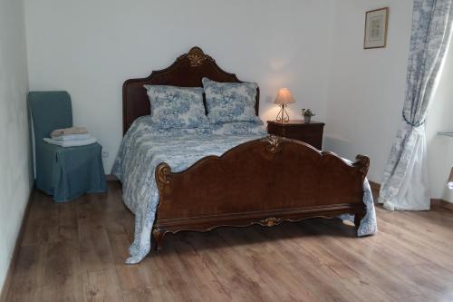 une chambre avec un grand lit avec des oreillers bleus dans l'établissement The Cottage, Clos des Archers, à Aigues-Vives