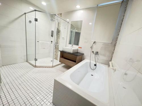 a bathroom with a tub and a shower and a sink at Tc慢旅花蓮館-近東大門夜市市中心 in Hualien City