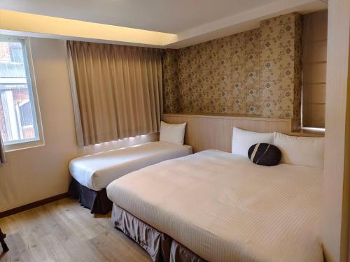 a hotel room with two beds and a window at Tc慢旅花蓮館-近東大門夜市市中心 in Hualien City