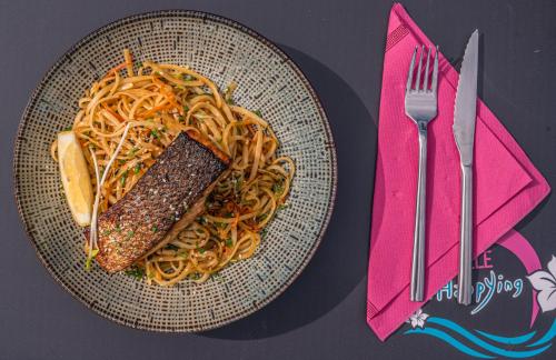 a plate of food with pasta and meat on a table at Camping L'Ocean in Brem-Sur-Mer