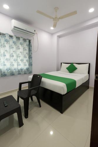 a bedroom with a bed and a chair in it at Hotel Rao Palace in Hyderabad