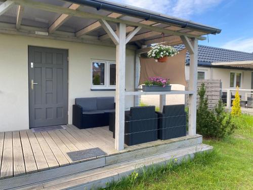 a pergola with a blue couch on a deck at Bajkowe Domki Marzeń Taborecik in Węgorzewo