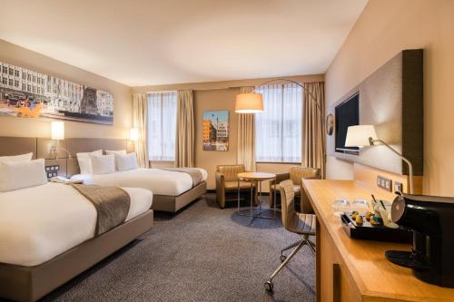 a hotel room with two beds and a television at Crowne Plaza Hotel Brugge by IHG in Bruges