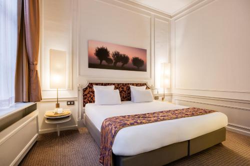 a hotel room with a bed and a painting on the wall at Crowne Plaza Hotel Brugge by IHG in Bruges