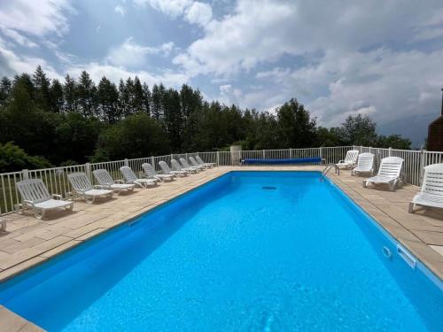 une piscine avec des chaises longues et une piscine dans l'établissement Pierre et Vacances Les Bergers au Pied des pistes & Piscine -Sauna & Balcon Sud, à L'Alpe-d'Huez