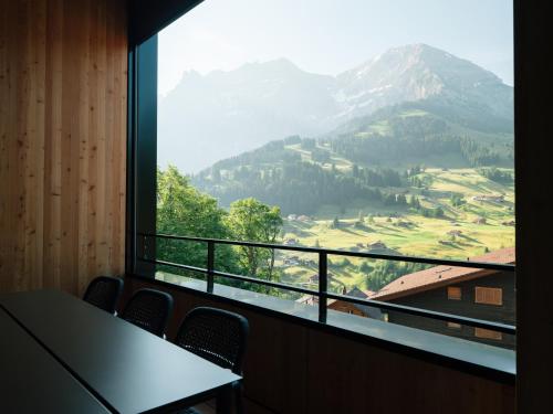 a room with a large window with a view of a mountain at KURVE Apartments & Lounge in Adelboden