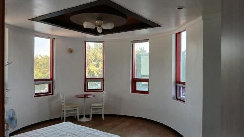 a room with a bed and a table and windows at Namhae Beach Hotel in Namhae