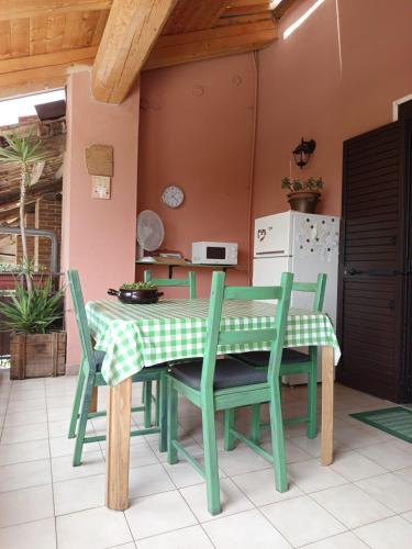 Una cocina con una mesa y sillas en una habitación. en BB6 di Elena e Roberto, en Casavecchie