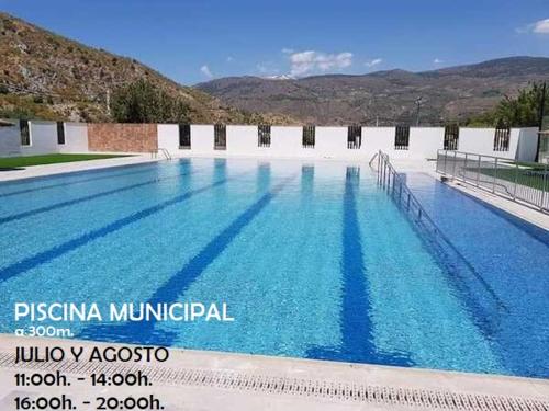 a large swimming pool with blue water at El almendro de Maruja in Torviscón