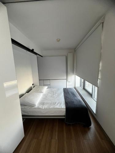 a small bedroom with a bed and a window at Silver Apartments in Wrocław