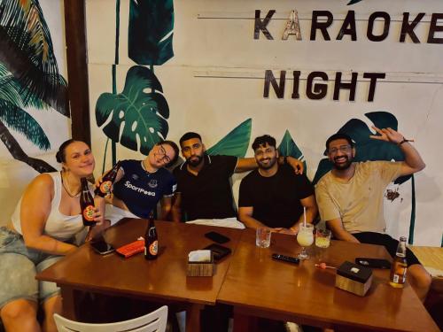 a group of people sitting at a table with drinks at Chill Out Hostel in Boracay