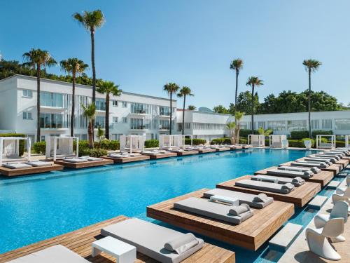 an image of a swimming pool with chaise lounge chairs at So White Beach Resort in Ayia Napa