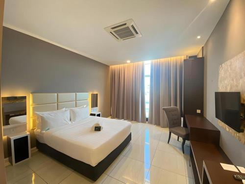 a hotel room with a bed and a television at Stirling Suites Hotel & Serviced Apartment in Miri