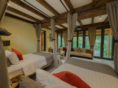 a bedroom with two beds and a living room at AMAYA HOME - Lodge, Spa & Restaurant in Hanoi