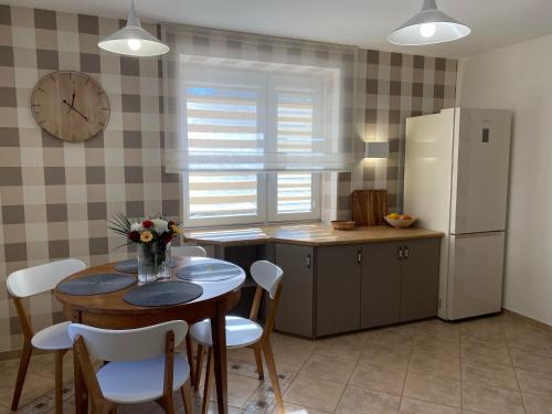 a kitchen with a table with chairs and a refrigerator at Apartamenty na Klasztornej in Jasło