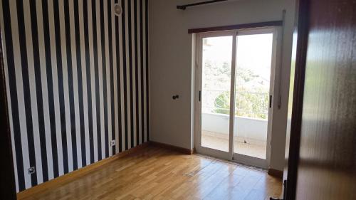 an empty room with a sliding glass door and a balcony at Casa Anita - Apartamento em Sobreda - Charneca da Caparica in Sobreda