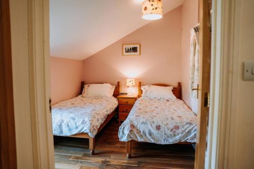 a bedroom with two beds and a dresser at Charming Rural Escape with Hot Tub Play Room BBQ in Llawhaden