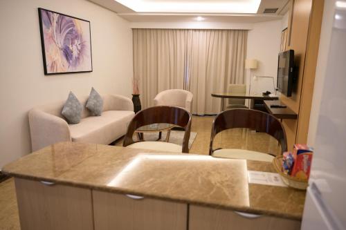 a living room with a couch and a table and chairs at Best Western Plus Mahboula in Kuwait