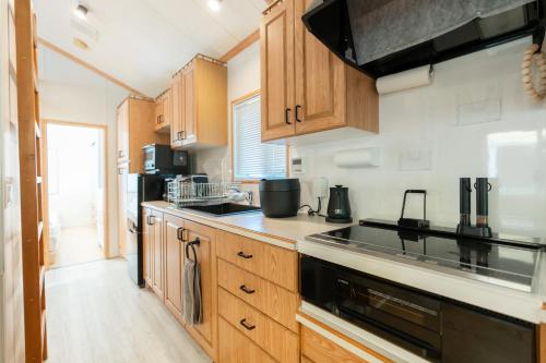 a kitchen with wooden cabinets and black appliances at なかやまHouse in Sumoto