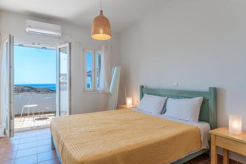 a bedroom with a bed with a view of the ocean at Sun Blooming Villa In Tinos Island in Agios Romanos