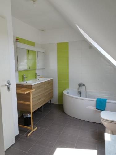 a bathroom with a sink and a tub and a toilet at Maison 12 pers Douarnenez kerlaz 2 étoiles Atout France in Kerlaz