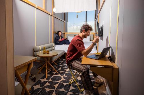 a man sitting at a desk in front of a laptop at Atura Adelaide Airport in Adelaide