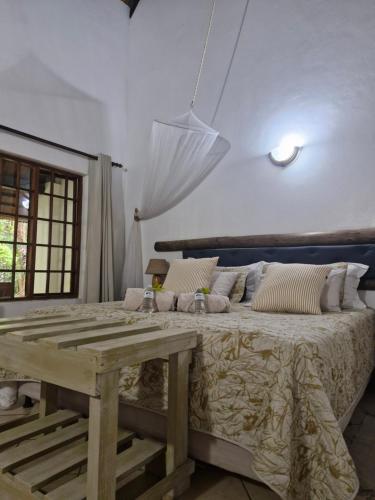 a bedroom with a large bed and a wooden table at African Ambience Guest House in St Lucia