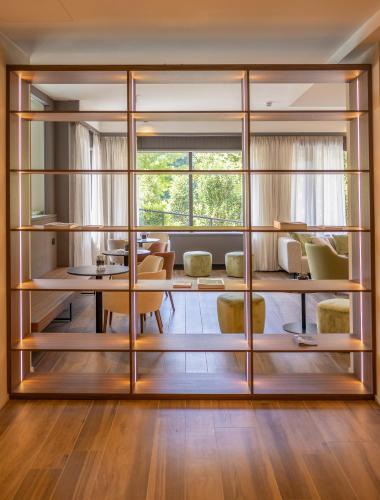 a room with a large glass partition with a table and chairs at Alchimia WellResort in Comano Terme