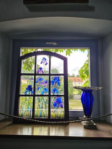 a window with a blue vase on a table at Hotel Marmułowski in Wejherowo