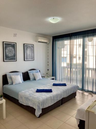 a bedroom with a large bed and a large window at DK Apartmani in Dobra Voda