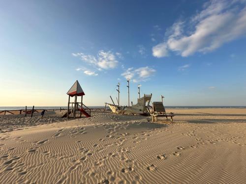 Una playa con un banco y un barco en la arena. en K Sunrise, en Ostende