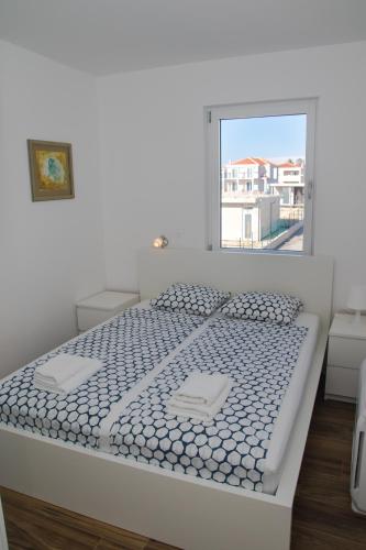 a white bed in a room with a window at Villa Miri Melon in Privlaka