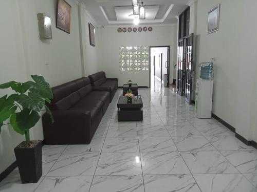 a living room with a couch and a table at Hotel Grand Ansara Mentari in Baturaja