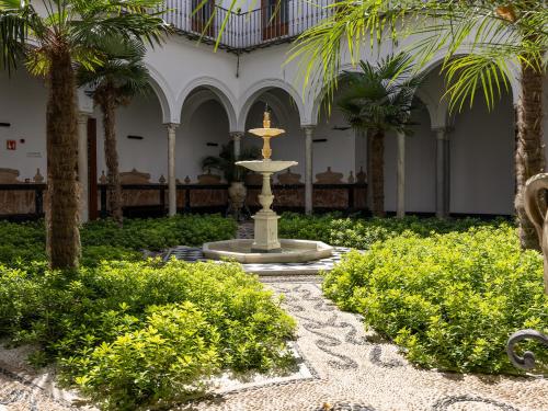 una fuente en medio de un patio con palmeras en Mercer Residences Sevilla, en Sevilla